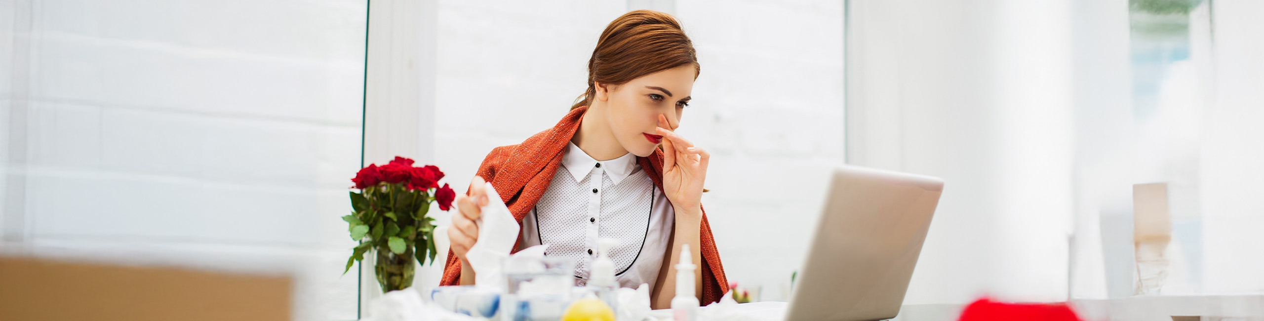 Külmetushaigusega naine kontoris.