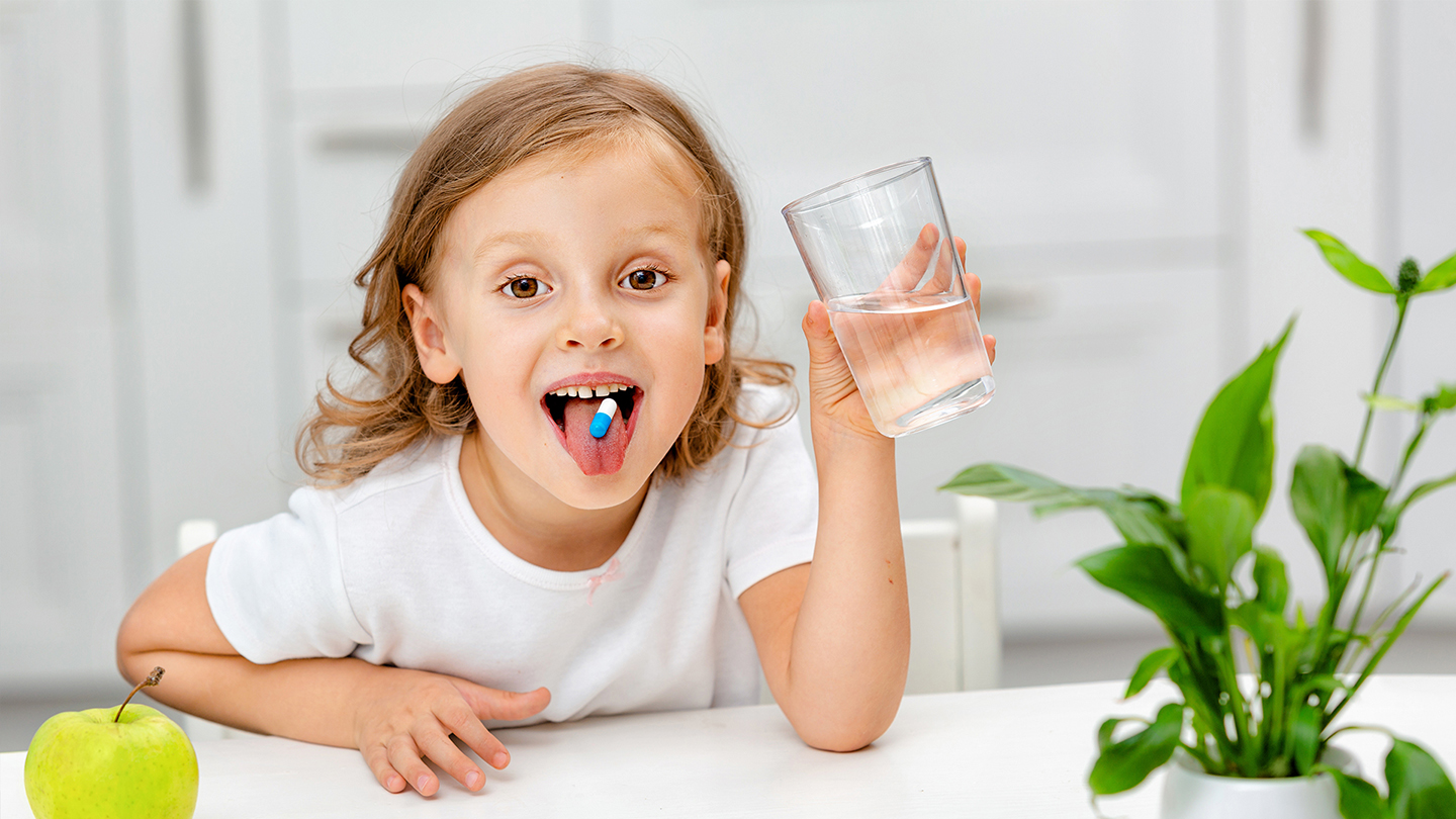 Noor koolitüdruk võtab immuunsuse tugevdamiseks toidulisandeid.