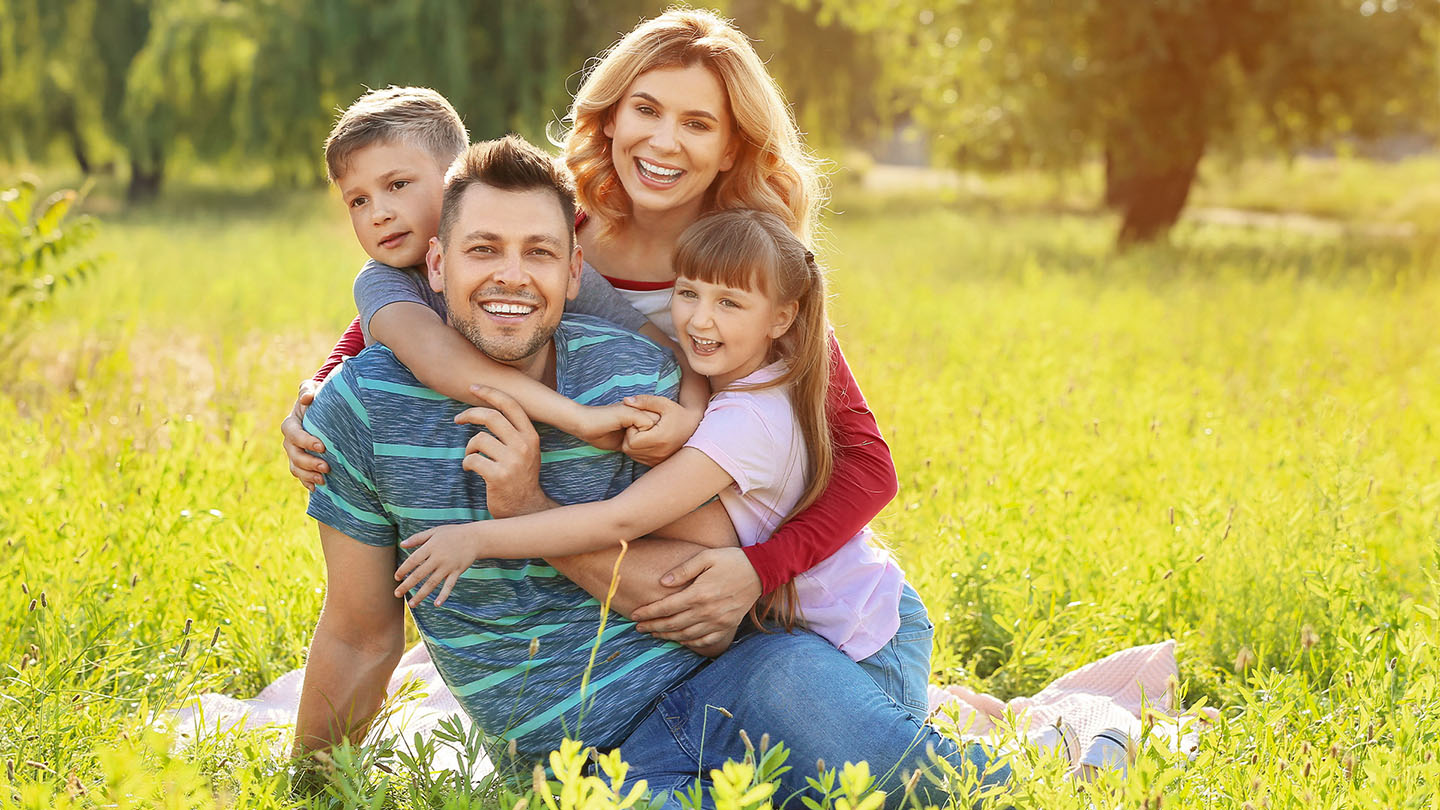 Õnnelik pere piknikul looduses.